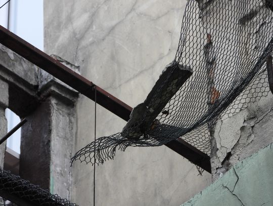 Uwaga! Tu może dojść do tragedii. Nad ul. Cyganka fragmenty elewacji wiszą na krawędziach siatki zabezpieczającej
