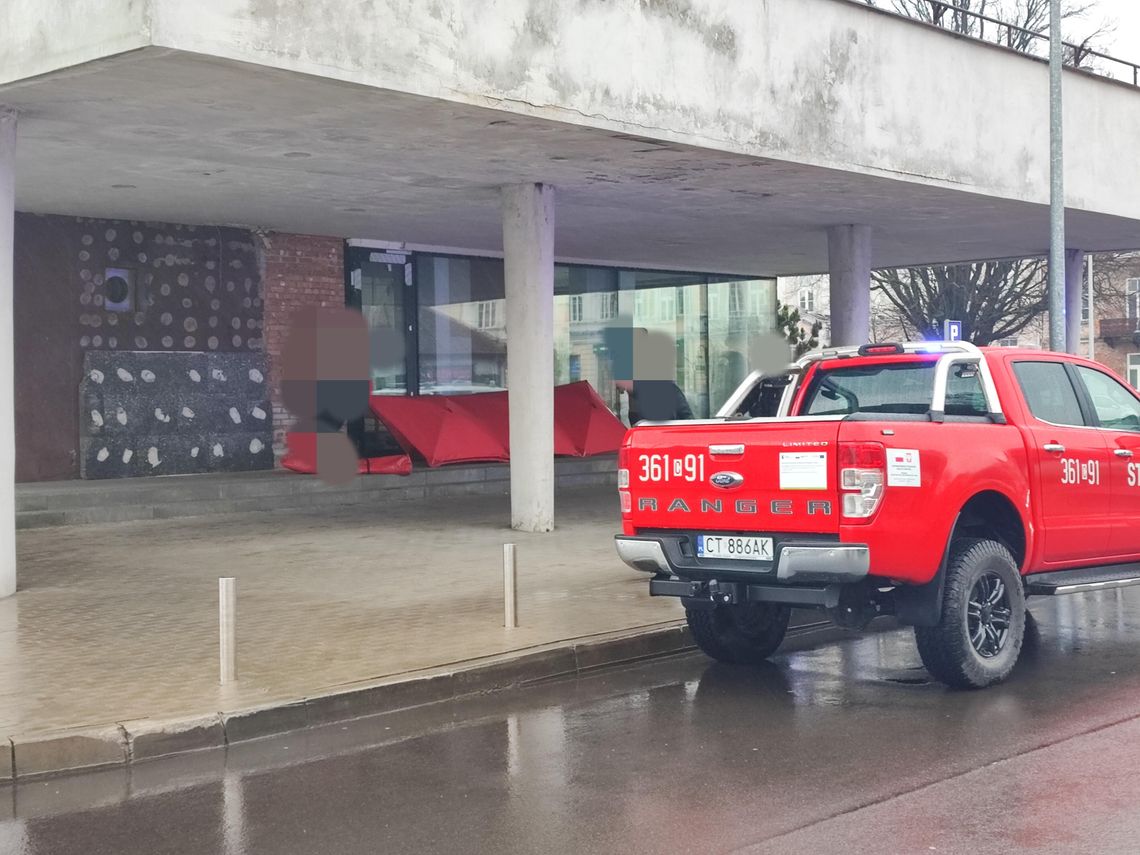 Parawan strażacki na schodach przed Hotelem Kujawy. Mężczyzna nie żyje
